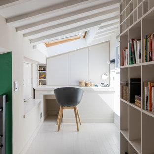 Kleines Stilmix Arbeitszimmer mit Arbeitsplatz, weißer Wandfarbe, gebeiztem Holzboden, Einbau-Schreibtisch, weißem Boden und freigelegten Dachbalken in Paris