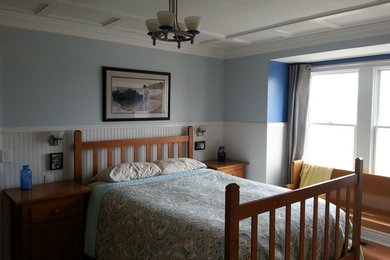 Modelo de dormitorio principal campestre de tamaño medio con paredes azules