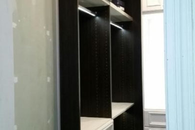 Modelo de armario vestidor unisex bohemio de tamaño medio con armarios tipo vitrina, puertas de armario de madera en tonos medios y suelo de madera oscura