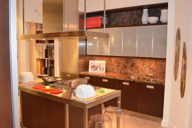 Eat-in kitchen photo in New York with a double-bowl sink, stainless steel cabinets, stainless steel countertops and stainless steel appliances