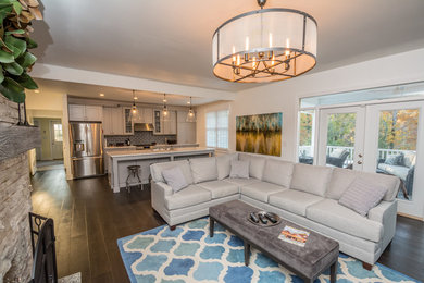 Living room - mid-sized transitional open concept dark wood floor and brown floor living room idea in Nashville with gray walls, a two-sided fireplace, a stone fireplace and a wall-mounted tv