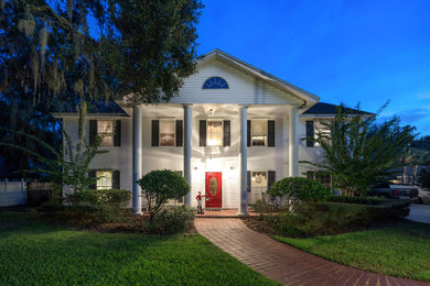 Example of a classic white two-story wood house exterior design in Jacksonville with a shingle roof