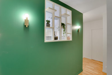 Réalisation d'une entrée tradition de taille moyenne avec un couloir, un mur vert et parquet clair.