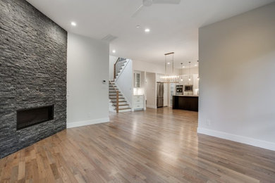 Example of a large open concept brown floor living room design in Dallas with white walls, a corner fireplace, a tile fireplace and no tv