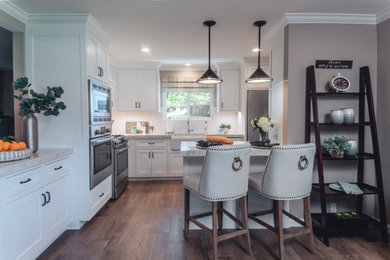 Small elegant eat-in kitchen photo in Orange County with a farmhouse sink, shaker cabinets, white cabinets, white backsplash, subway tile backsplash and stainless steel appliances