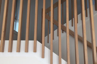 Imagen de escalera en L contemporánea de tamaño medio con escalones de madera y contrahuellas de madera