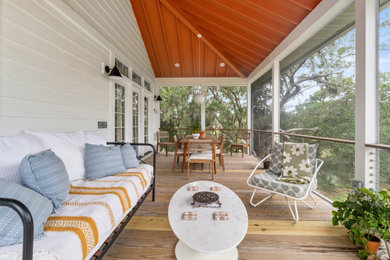 Large beach style screened-in and cable railing back porch idea in Charleston with decking and a roof extension