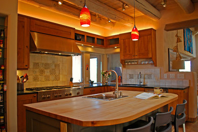 Inspiration for a large southwestern l-shaped light wood floor eat-in kitchen remodel in Albuquerque with an undermount sink, recessed-panel cabinets, medium tone wood cabinets, quartzite countertops, beige backsplash, ceramic backsplash, stainless steel appliances and an island