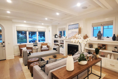 Großes, Fernseherloses Maritimes Wohnzimmer mit weißer Wandfarbe, braunem Holzboden, Kamin und gefliester Kaminumrandung in San Diego
