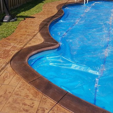 Ashlar Slate pool deck with interior, acid stained border and bull-nose coping.