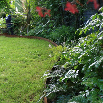 Curving back garden with office and swing