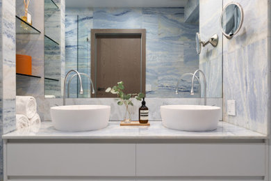 ニューヨークにある高級な中くらいなコンテンポラリースタイルのおしゃれな浴室 (白いキャビネット、ベッセル式洗面器、洗面台2つ、フローティング洗面台、マルチカラーのタイル、マルチカラーの壁、大理石の床、大理石の洗面台、マルチカラーの床、白い洗面カウンター、トイレ室) の写真