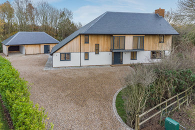This is an example of a medium sized and brown classic front detached house in Kent with a grey roof.