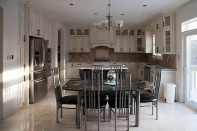 Inspiration for a timeless porcelain tile kitchen remodel in Toronto with a single-bowl sink, beige cabinets, granite countertops, brown backsplash, stone tile backsplash, stainless steel appliances and an island