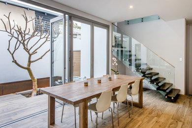 This is an example of a contemporary dining room in Perth with medium hardwood floors.
