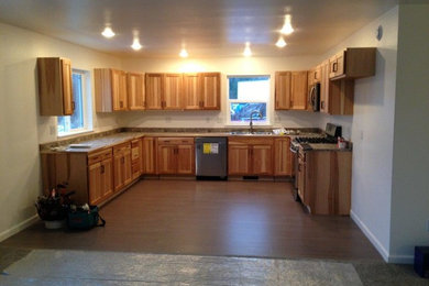 Eat-in kitchen - mid-sized traditional u-shaped dark wood floor eat-in kitchen idea in Other with a double-bowl sink, recessed-panel cabinets, light wood cabinets, granite countertops, stainless steel appliances and no island