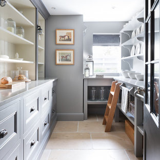 Design ideas for a mid-sized traditional galley kitchen pantry in Essex with shaker cabinets, grey cabinets, stainless steel benchtops, travertine floors and beige floor.