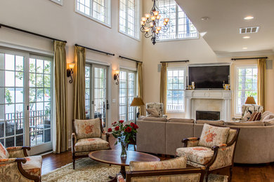 Example of a mid-sized classic formal and open concept medium tone wood floor and brown floor living room design in Other with beige walls, a standard fireplace, a tile fireplace and a wall-mounted tv