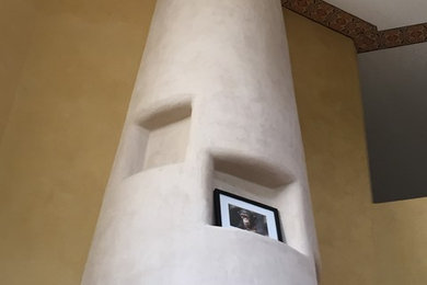 Example of a huge southwest loft-style living room design in Albuquerque with multicolored walls and a plaster fireplace