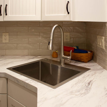 White Kitchen with Calcutta Marble Laminate Countertop and Tile Backsplash