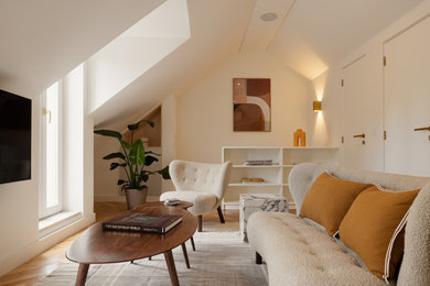 Living room - mid-sized contemporary loft-style medium tone wood floor, vaulted ceiling and brown floor living room idea in San Francisco with white walls, a wall-mounted tv and no fireplace