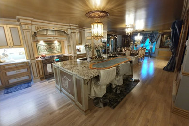 Example of a large classic single-wall light wood floor and beige floor eat-in kitchen design in Toronto with an undermount sink, flat-panel cabinets, beige cabinets, granite countertops, blue backsplash, stainless steel appliances, an island and multicolored countertops