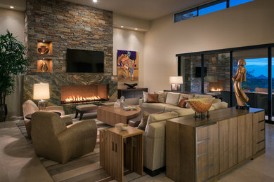 Example of a large trendy open concept travertine floor living room design in Phoenix with beige walls, a standard fireplace, a stone fireplace and a wall-mounted tv