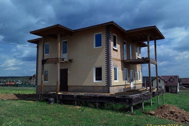 На фото: двухэтажный, бежевый дом среднего размера в современном стиле