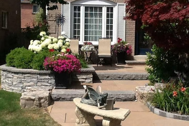 Example of a large classic front yard stamped concrete patio design in Toronto with no cover