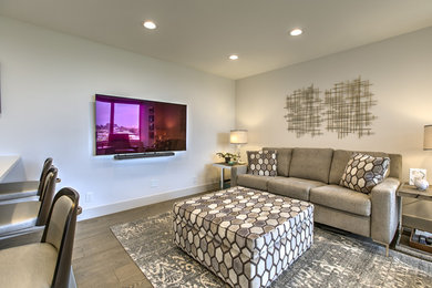 This is an example of a modern open concept living room in Omaha with medium hardwood floors, no fireplace and a wall-mounted tv.
