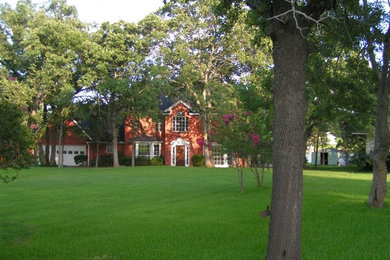 Mid-sized red two-story brick exterior home idea in Austin