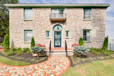 Elegant beige two-story stone house exterior photo in Other with a tile roof