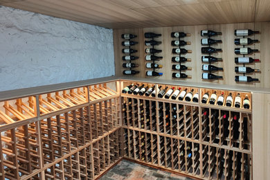 This is an example of a medium sized traditional wine cellar in Melbourne with brick flooring, storage racks and orange floors.