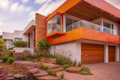 Large contemporary two-storey red exterior in Melbourne with metal siding.