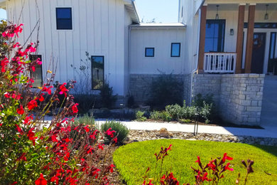Photo of a mid-sized transitional partial sun and drought-tolerant front yard landscaping in Austin.