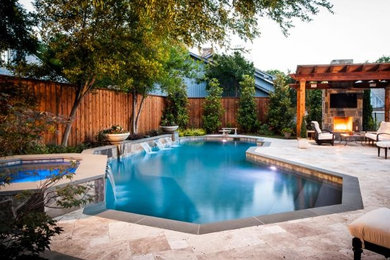 This is an example of a medium sized contemporary back custom shaped above ground swimming pool in Orange County with a water feature and natural stone paving.