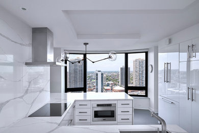 Inspiration for a mid-sized modern u-shaped porcelain tile and gray floor kitchen pantry remodel in Chicago with an undermount sink, flat-panel cabinets, white cabinets, quartz countertops, white backsplash, stone slab backsplash, paneled appliances, a peninsula and white countertops