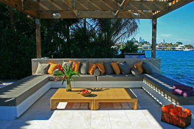 Photo of a mid-sized modern backyard patio in Miami with a pergola and tile.