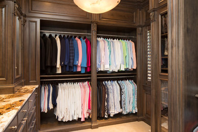 This is an example of a large traditional men's walk-in wardrobe in St Louis with carpet.