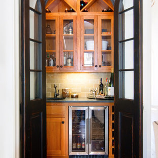 ニューオリンズの小さいトラディショナルスタイルのおしゃれなウェットバー (シェーカースタイル扉のキャビネット、中間色木目調キャビネット、ベージュキッチンパネル、濃色無垢フローリング) の写真