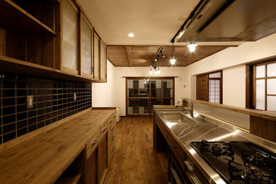 札幌にあるラグジュアリーな中くらいな和モダンなおしゃれなキッチン (一体型シンク、茶色いキャビネット、ステンレスカウンター、濃色無垢フローリング、茶色い床、茶色いキッチンカウンター) の写真