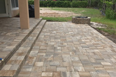 Inspiration for a mid-sized transitional backyard patio in Jacksonville with a fire feature, brick pavers and a roof extension.