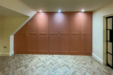 Design ideas for a large retro gender neutral built-in wardrobe in Sussex with shaker cabinets, vinyl flooring and brown floors.