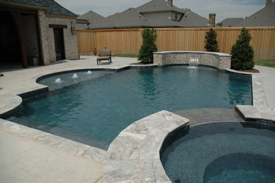 Hot tub - mid-sized mediterranean backyard stamped concrete and rectangular natural hot tub idea in Austin