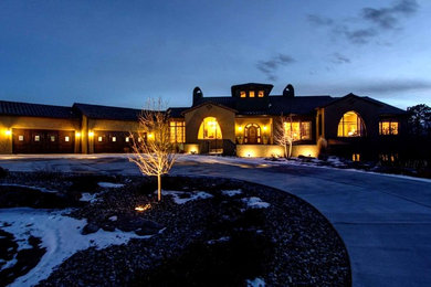 Inspiration for a huge mediterranean beige one-story stucco house exterior remodel in Denver with a hip roof and a tile roof