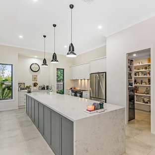 Large beach style kitchen pantry pictures - Kitchen pantry - large beach style galley kitchen pantry idea in Townsville with granite countertops, an island and white countertops
