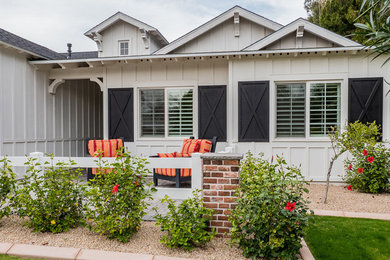 Country white board and batten exterior home photo in Phoenix with a black roof
