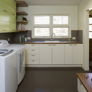 Midcentury utility room in DC Metro with green cabinets and brown floors.