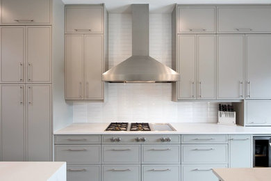 Inspiration for a transitional galley enclosed kitchen remodel in Austin with gray cabinets, quartzite countertops, white backsplash, cement tile backsplash, stainless steel appliances, an island and white countertops