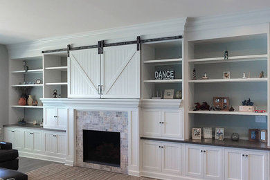 Large elegant open concept medium tone wood floor living room photo in Grand Rapids with gray walls, a tile fireplace, a standard fireplace and a concealed tv